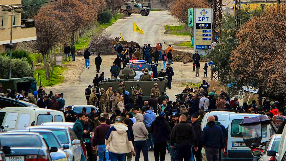 dpatopbilder - People stand behind armored vehicles of the Lebanese army while a sand barrier and an Israeli military jeep in the background block the road on the outskirts of the southern Lebanese village of Kfar Kila. Photo: Marwan Naamani/dpa