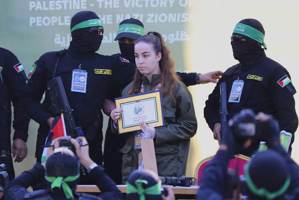 Israeli soldier Agam Berger stands with masked Islamic Jihad militants as she is handed over to the Red Cross at the Jabalya refugee camp in Gaza City, Thursday Jan. 30, 2025.(AP Photo/Mohammed Hajjar)