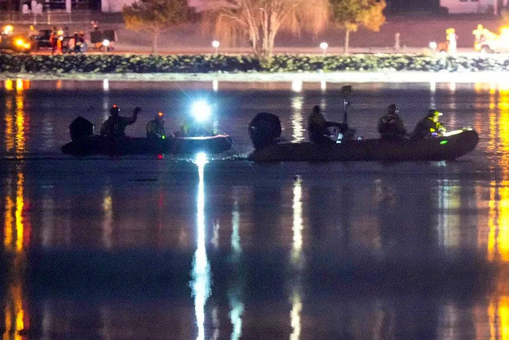 Rescue workers search the Potomac River where the passenger jet and helicopter crashed after colliding.