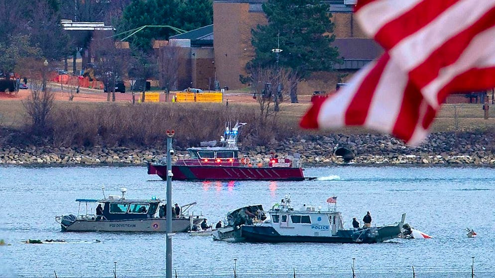 dpatopbilder - A diving team and a police boat are at work near the wreckage in the Potomac River at Ronald Reagan Washington National Airport. Photo: Jose Luis Magana/AP/dpa