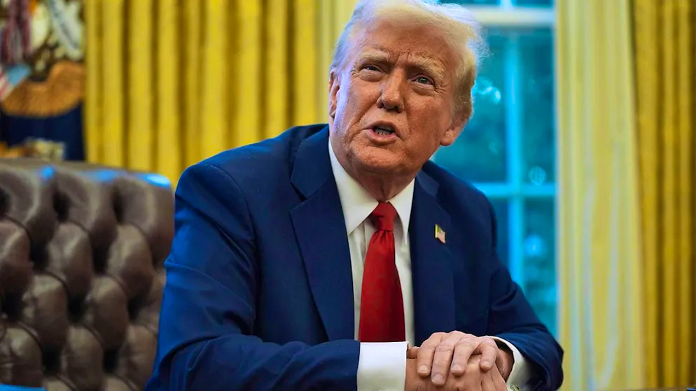 President Donald Trump speaks with reporters as he signs executive orders in the Oval Office of the White House. Photo: Evan Vucci/AP/dpa