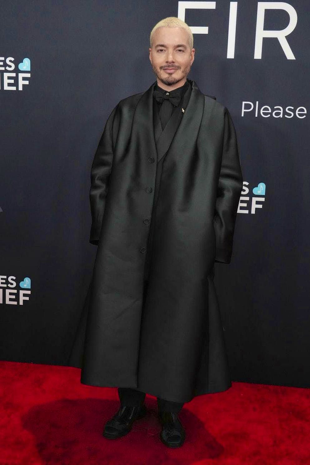 Grammy Awards 2025 - Red Carpet. J Balvin came in all black, but instead of a suit he chose an A-line cut oversized coat. The mix of tie and bow tie was also interesting.