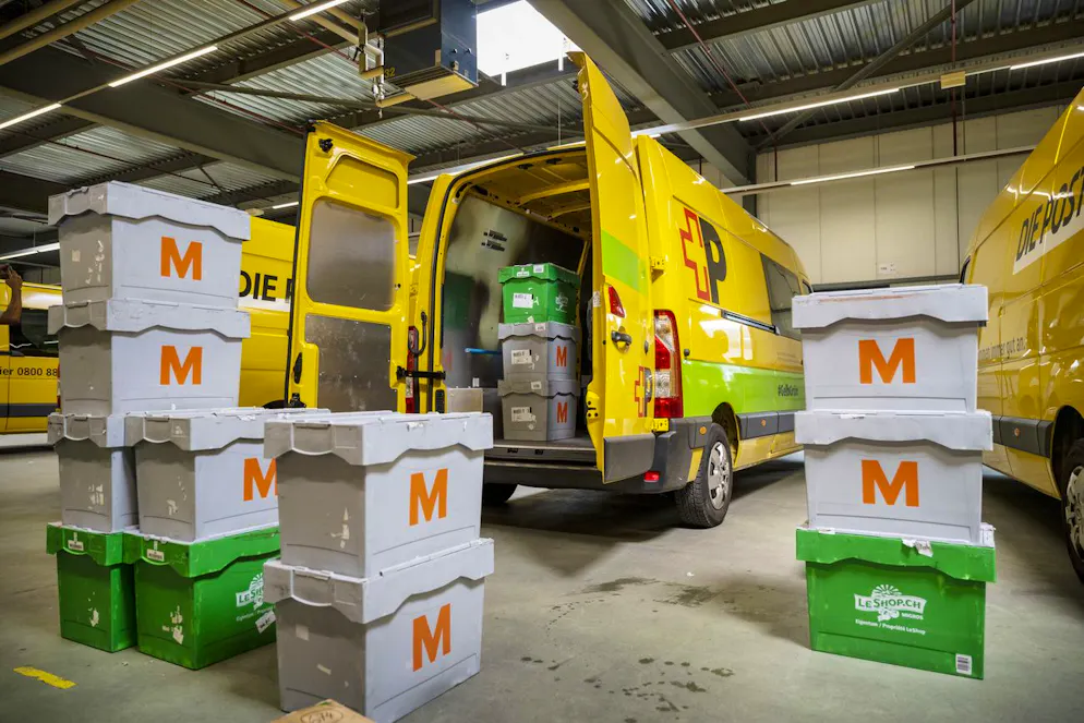 Ein Paketbote der Schweizerischen Post belädt ein Elektrofahrzeug in Ostermundigen.