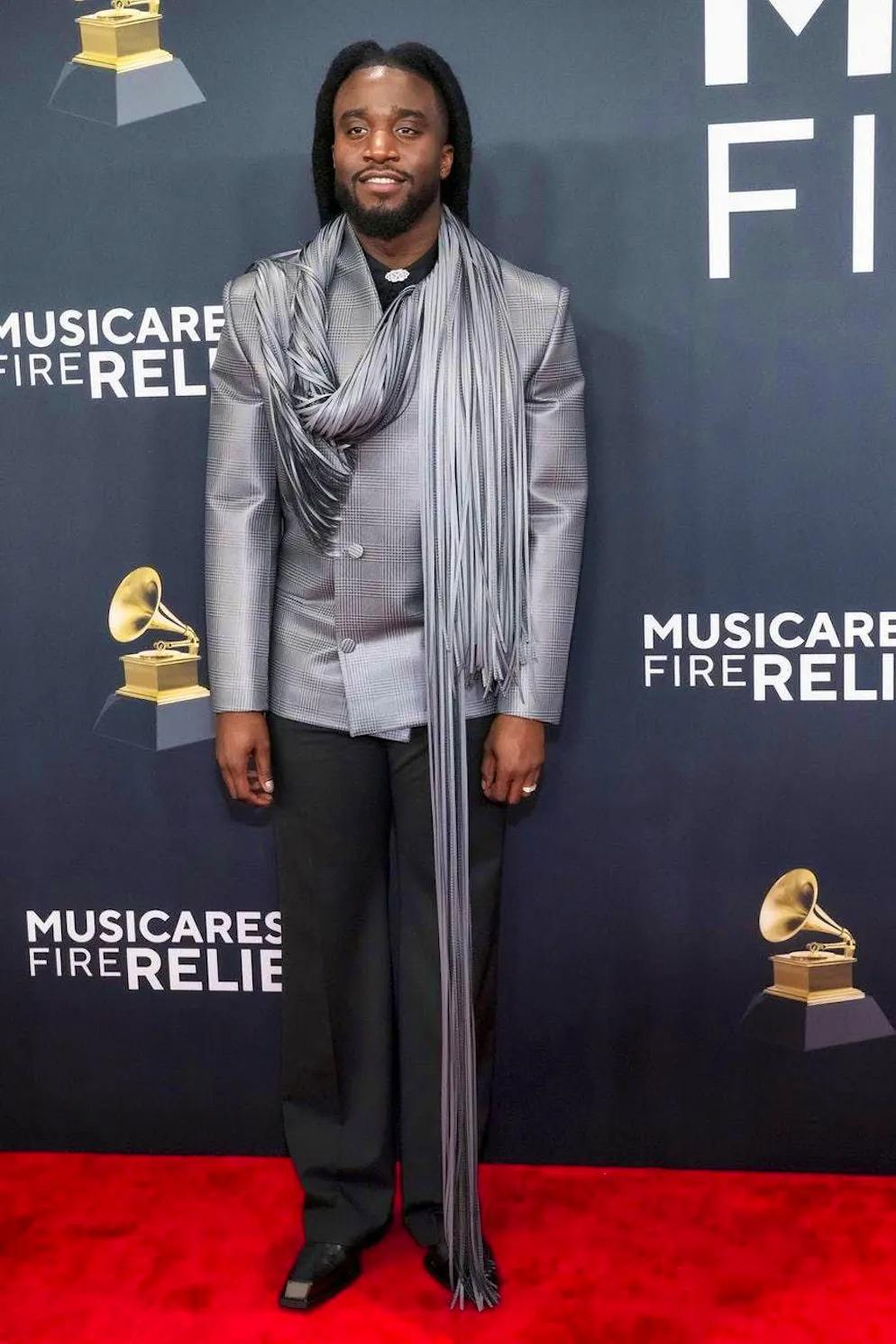 Grammy Awards 2025 - Tapis rouge. Shaboozey rompt le style de la veste de costume classique au motif pied-de-poule avec une écharpe à franges «surlongue».