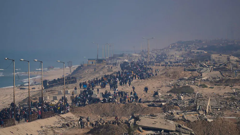Vertriebene Palästinenser gehen auf einer Straße im Zentrum des Gazastreifens, um nach dem Waffenruheabkommen zwischen Israel und der Hamas in ihre Häuser im nördlichen Gazastreifen zurückzukehren. Foto: Abdel Kareem Hana/AP/dpa