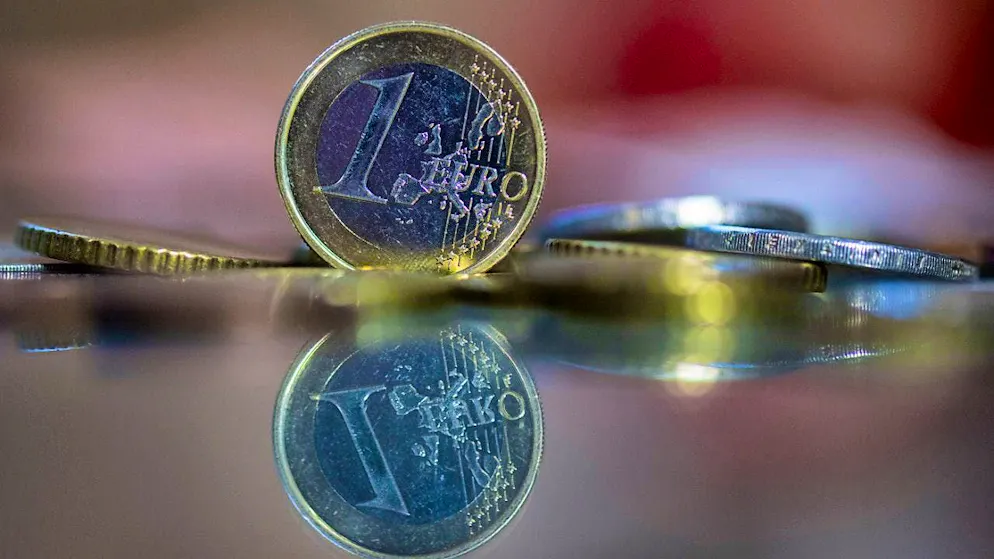 ILLUSTRATION - A 1 euro coin stands on a table, surrounded by other euro coins. After months of dispute, France's parliament has finally passed the budget for the current year. Photo: Hendrik Schmidt/dpa/Archiv