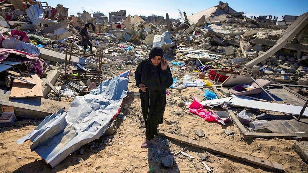 Manual Aslim walks through the rubble of her destroyed house in Rafah in the southern Gaza Strip. Photo: Abdel Kareem Hana/AP/dpa
