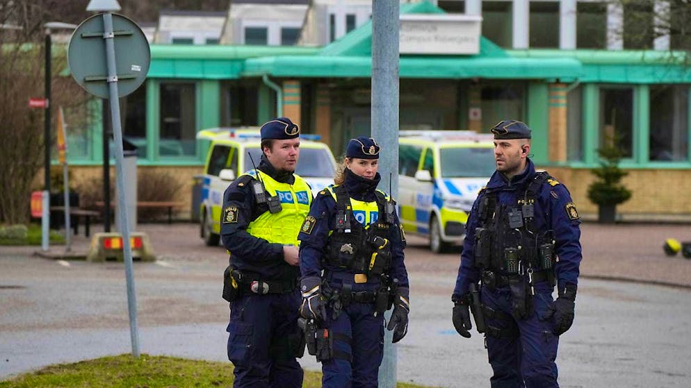 Police officers stand near the Risbergska Campus educational center. Photo: Sergei Grits/AP/dpa