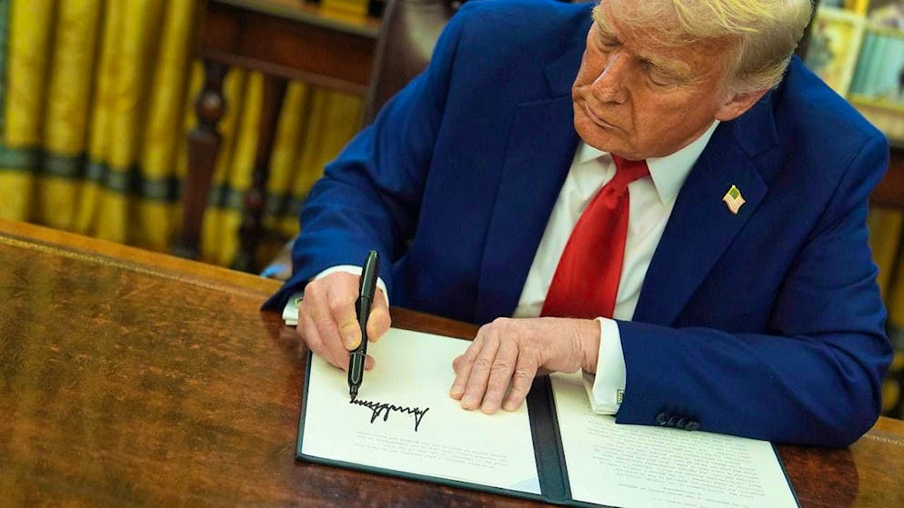 ARCHIVE - US President Donald Trump signs an executive order in the Oval Office of the White House in Washington. Photo: Evan Vucci/AP/dpa
