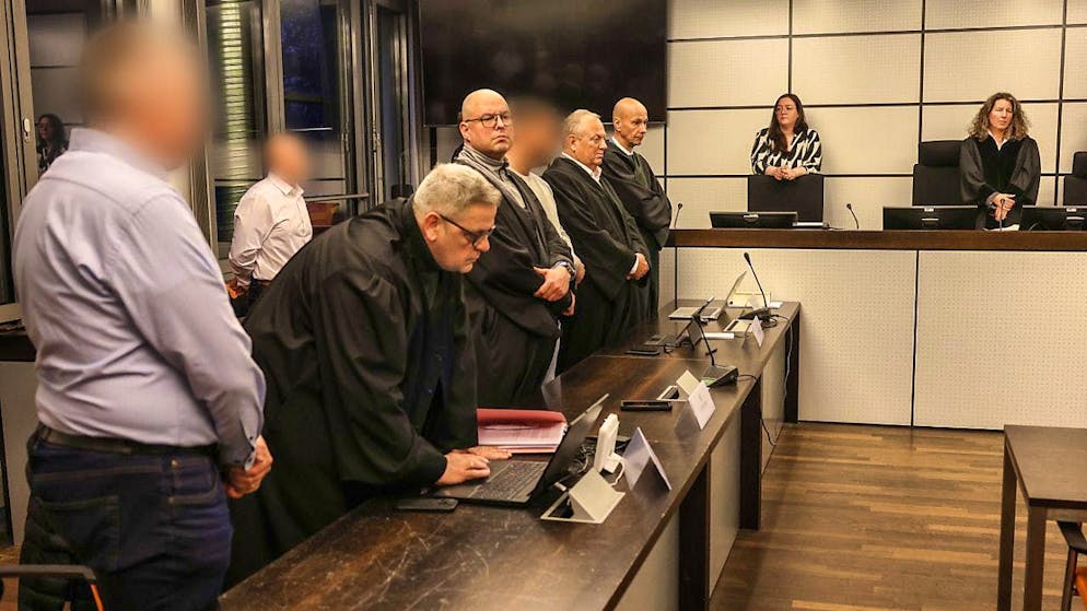 The three defendants stand between lawyers before the verdict is announced. Photo: Oliver Berg/dpa - ATTENTION: Person(s) has/have been pixelated for legal reasons