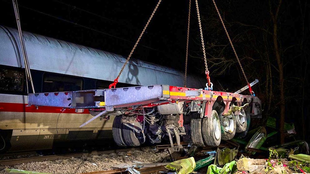 A truck trailer is recovered with a crane after a train accident. One person was killed and several injured when an ICE train collided with a truck. Photo: Daniel Bockwoldt/dpa/Daniel Bockwoldt