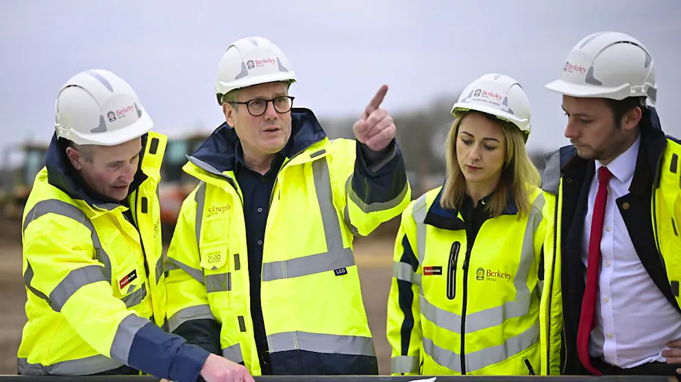Le Premier ministre britannique Keir Starmer (au centre) s'est rendu jeudi matin sur un site de construction au nord de Londres afin de dévoiler les plans de son gouvernement pour "la prochaine génération de nouvelles villes".