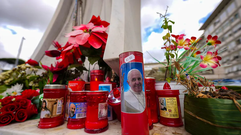 Kerzen, eine davon mit einem Foto von Papst Franziskus, stehen vor der Poliklinik Agostino Gemelli, wo Papst Franziskus ins Krankenhaus eingeliefert wurde, um sich einigen notwendigen diagnostischen Tests zu unterziehen und seine laufende Behandlung wegen Bronchitis fortzusetzen. Foto: Andrew Medichini/AP/dpa