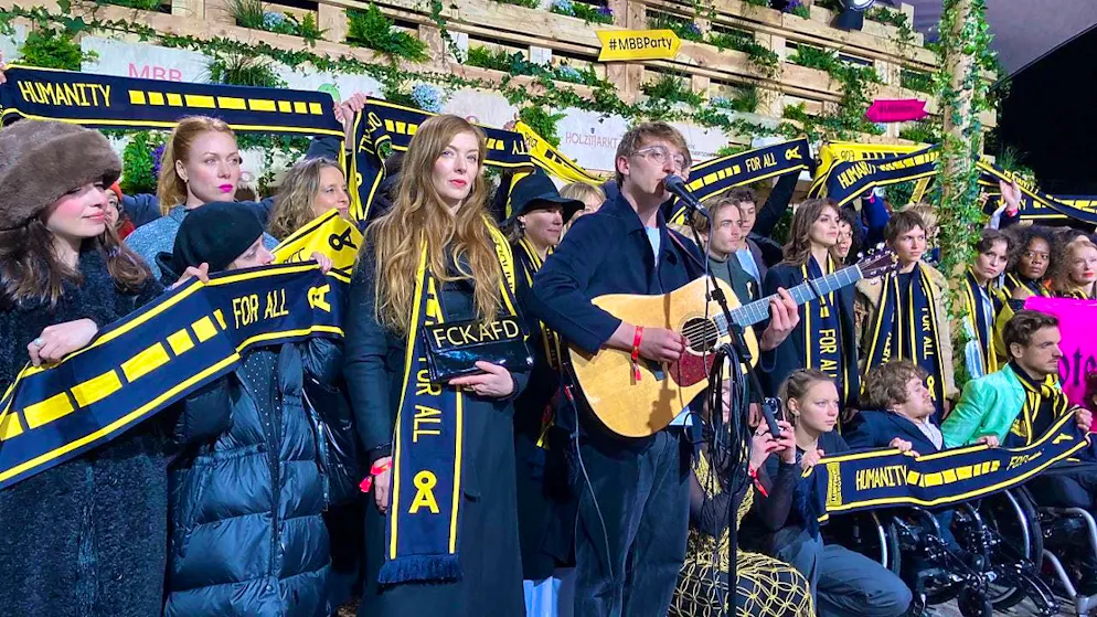 Singer Marlo Großhardt (M) takes part with actors and celebrities in a protest organized by SOS Humanity during the Berlinale at the Medienboard Berlin-Brandenburg Party. Photo: Anna Ross/dpa