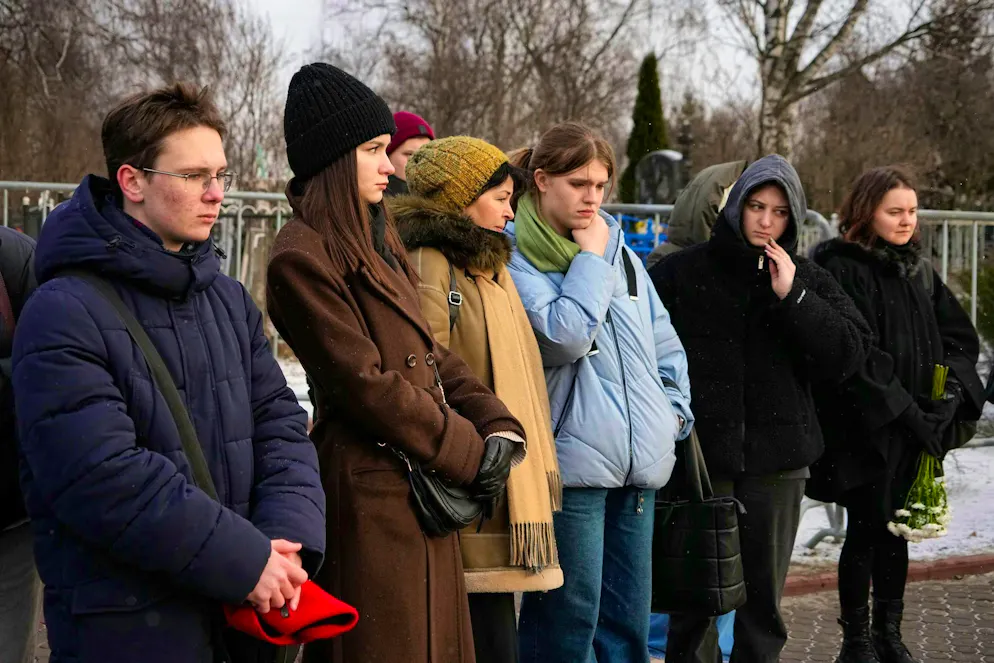 People stand at the grave of Russian opposition leader Alexei Navalny at Borisovskoye Cemetery in Moscow, one year after his death.