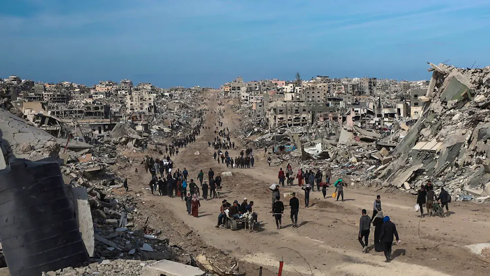 ARCHIV - Palästinenser gehen durch die Zerstörung, die die israelische Luft- und Bodenoffensive in Dschabalija angerichtet hat, nachdem ein Waffenstillstandsabkommen zwischen Israel und der Hamas in Kraft getreten ist. Foto: Abed Hajjar/AP/dpa