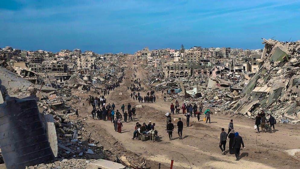 ARCHIVE - Palestinians walk through the destruction caused by the Israeli air and ground offensive in Jabaliya after a ceasefire agreement between Israel and Hamas came into force. Photo: Abed Hajjar/AP/dpa