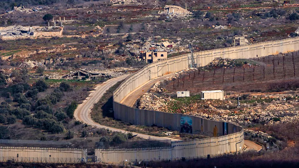 ARCHIV - Eine Mauer markiert die israelisch-libanesische Grenze in der Nähe des Dorfes Odaisseh im Südlibanon, aufgenommen im Norden von Israel. Foto: Ariel Schalit/AP/dpa