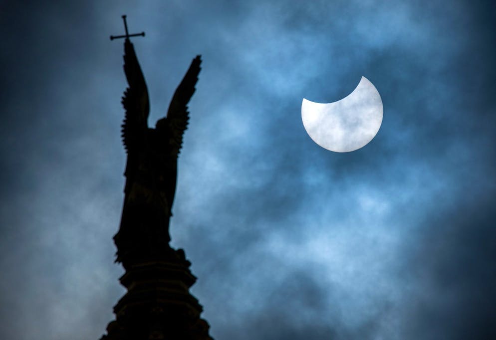 Sonne, Mond und Sterne im März – Mond- und Sonnenfinsternis - Gallery. Eine partielle Sonnenfinsternis über der Statue des Erzengel Michael auf der Kuppel des Schweriner Schlosses.