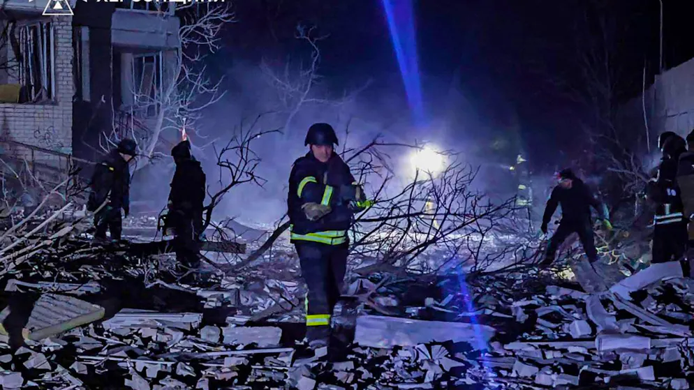 HANDOUT - Rettungskräfte räumen die Trümmer eines mehrstöckigen Gebäudes in Cherson weg. Foto: Ukrainian Emergency Service/AP/dpa - ACHTUNG: Nur zur redaktionellen Verwendung im Zusammenhang mit einer Berichterstattung und nur mit vollständiger Nennung des vorstehenden Credits