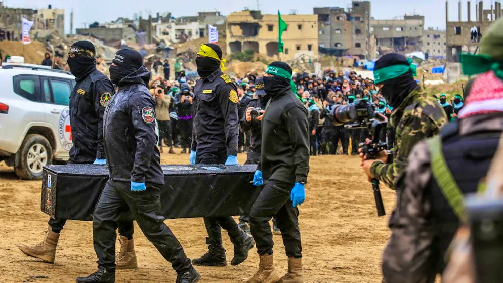 Masked members of the terrorist organization Hamas carry a coffin. Photo: Abed Rahim Khatib/dpa