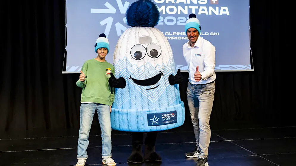 Adam, ein Schüler aus Fully, und WM-Direktor Didier Défago präsentieren Tsapé, das Maskottchen für die Ski-WM 2027 in Crans-Montana