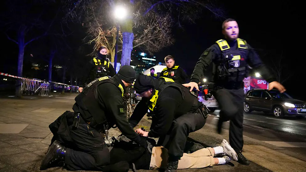Polizeibeamte halten einen Mann am Holocaust-Mahnmal fest, nachdem ein anderer Mann schwer verletzt wurde. Foto: Ebrahim Noroozi/AP/dpa