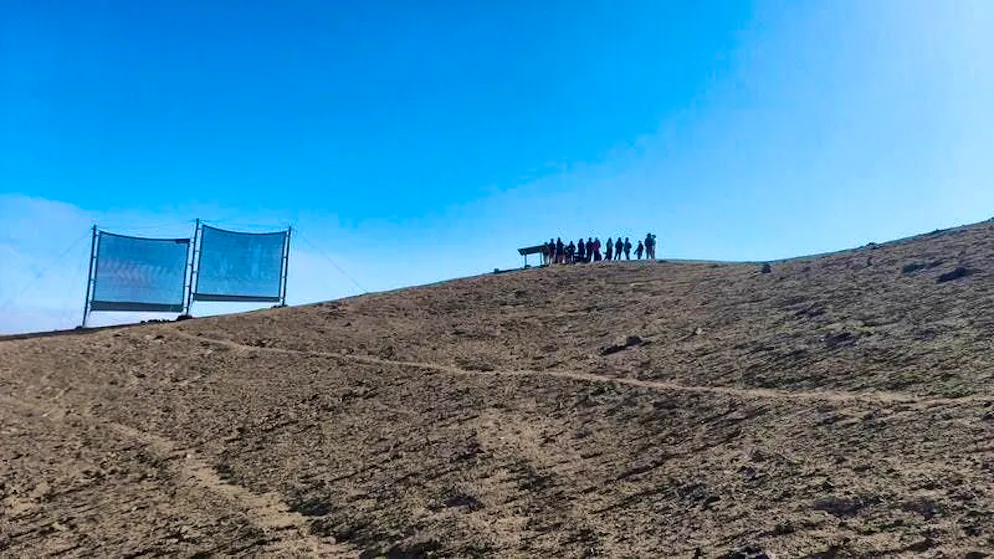 Students stand next to secondary collectors outside the town of Alto Hospicio.