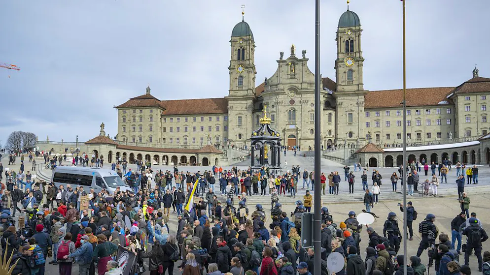 Geschützt von der Polizei, zieht der Demonstrationszug gegen Weidel und die AfD am Kloster Einsiedeln vorbei.