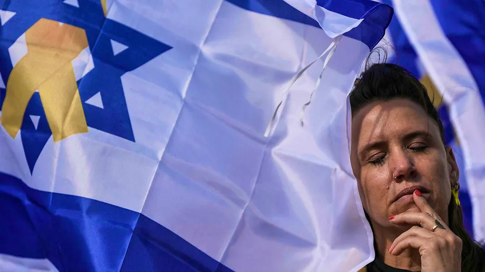 A woman stands next to an Israeli flag at the hostage site in Tel Aviv. Photo: Oded Balilty/AP/dpa/Archive image