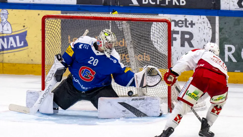 Die Entscheidung in Freiburg: Anthony Greco (rechts) erzielt in der Verlängerung das 4:3-Siegtor für den EHC Biel gegen Gottérons Goalie Reto Berra