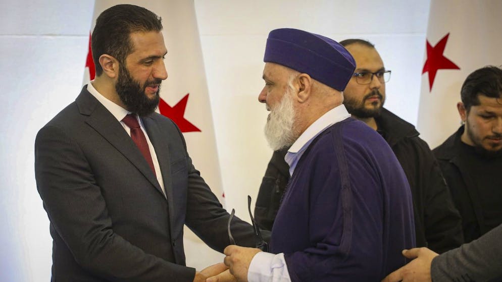 Der syrische Übergangspräsident Ahmed al-Scharaa (l.) begrüsst am Dienstag in Damaskus Delegierte bei der Konferenz zum nationalen Dialog.