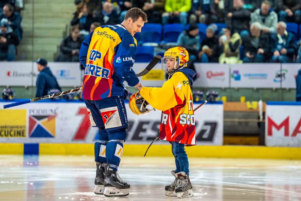 Paride Duca übergibt Dominik Kubalik den Top-Scorer-Helm.
