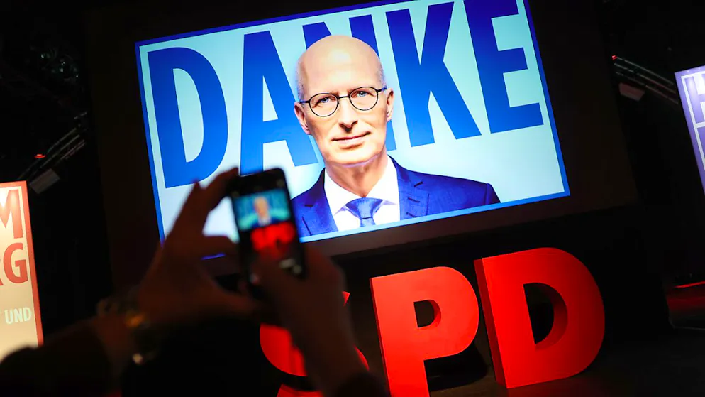 Eine Person fotografiert mit dem Smartphone eine Videowand mit dem Schriftzug «Danke» und dem Gesicht von Peter Tschentscher (SPD), Erster Bürgermeister von Hamburg, bei der Wahlparty der Hamburger SPD in der Markthalle. In Hamburg wurde am Sonntag eine neue Bürgerschaft gewählt. Foto: Christian Charisius/dpa