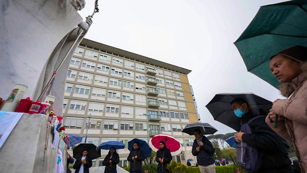 Menschen beten für Papst Franziskus vor der Poliklinik Agostino Gemelli. Foto: Andrew Medichini/AP/dpa