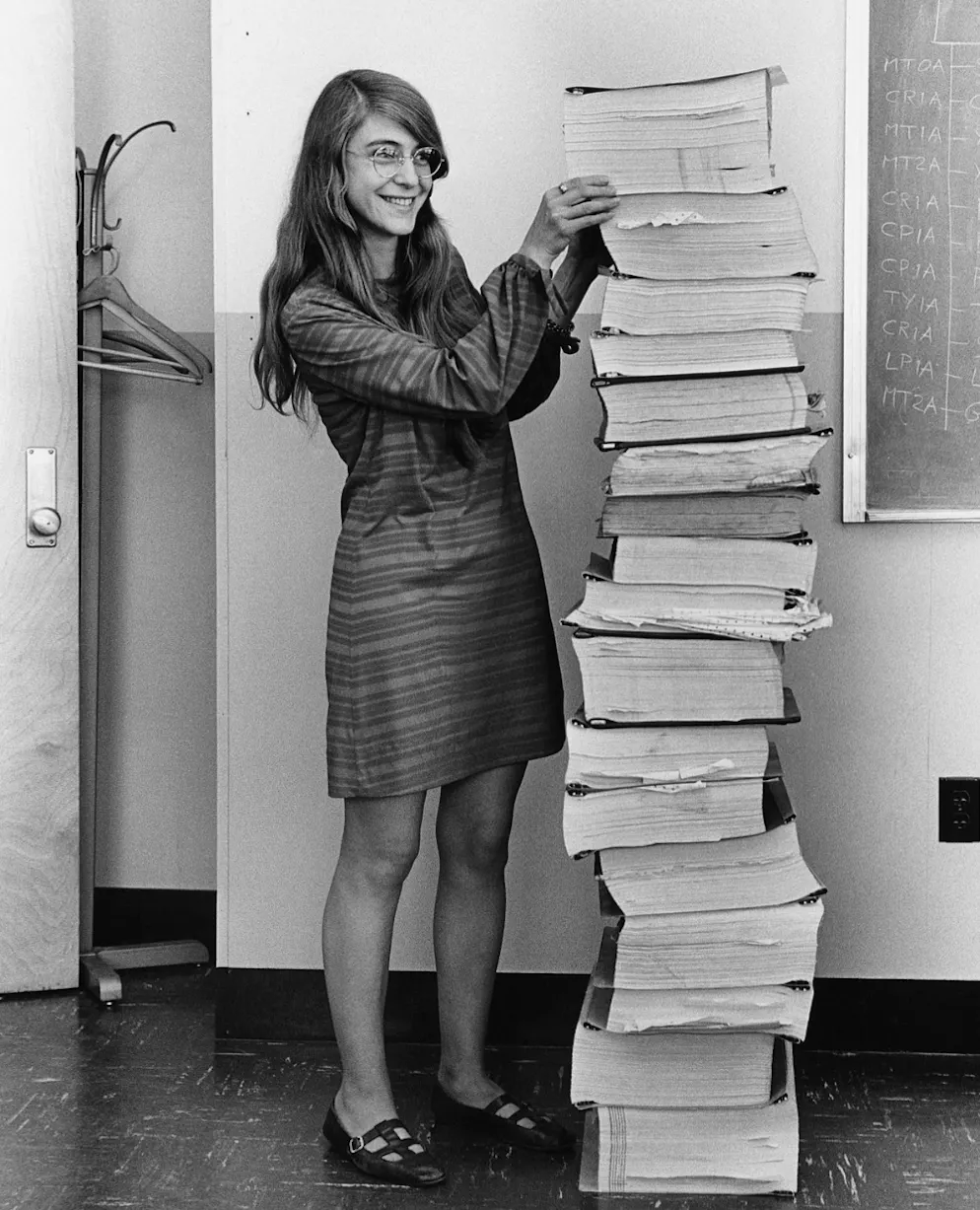 Margaret Hamilton neben Ausdrucken der Apollo-Flugsoftware.