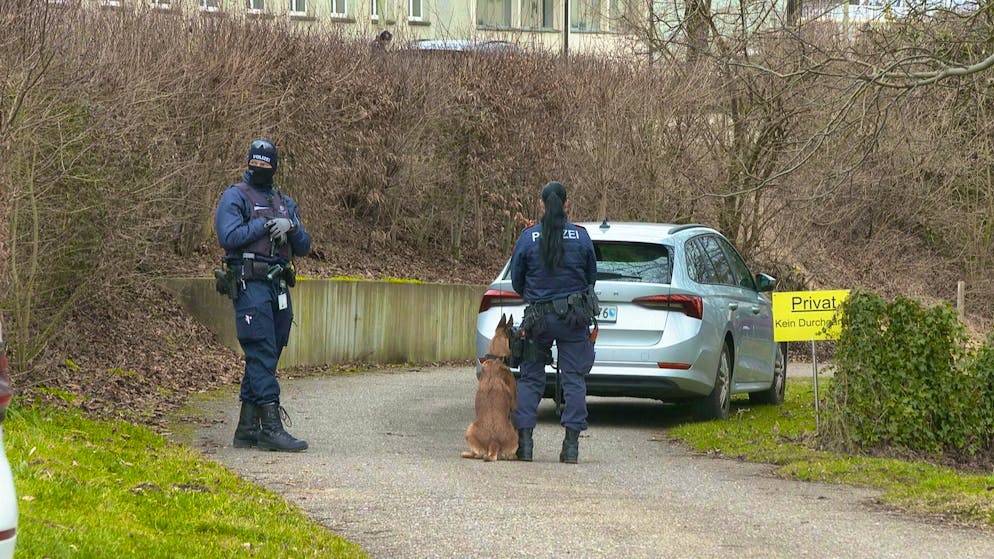 Heavily armed police officers in front of the man's house. 