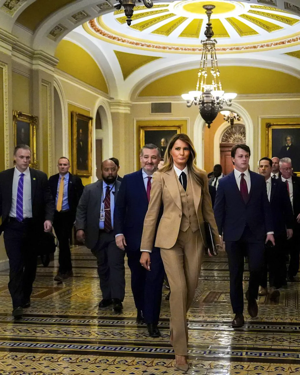 Melania Trump en power suit et cravate. Le costume – souvent accompagné d’une cravate – incarne rigueur et fiabilité.