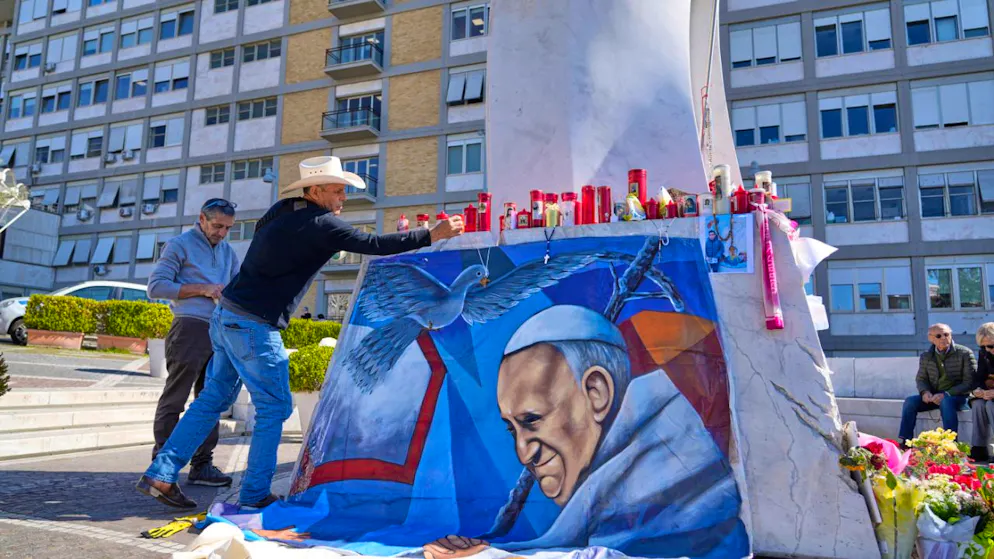 dpatopbilder - Der mexikanische Maler Roberto Marquez stellt ein von ihm gemaltes Bild von Papst Franziskus vor dem Krankenhaus Agostino Gemelli in Rom auf. Foto: Gregorio Borgia/AP/dpa