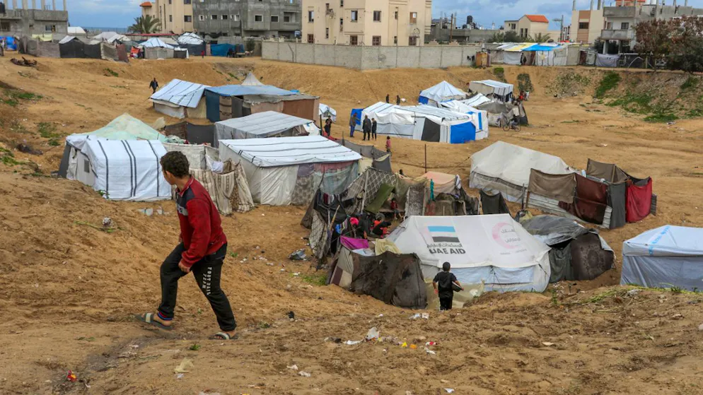 Ein Kind betrachtet die Zelte der vertriebenen Palästinenser in Al Mawasi. Israel verhindert nach wie vor die Zufahrt von mobilen Unterbringungsmöglichkeiten für vertriebenen Palästinenser, deren Häuser von der israelischen Armee vor ihrem Rückzug aus einigen Städten des Gazastreifens zerstört wurden. Foto: Abed Rahim Khatib/dpa