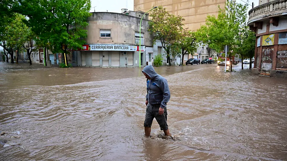 Eine Person watet durch eine überschwemmte Straße nach einem Unwetter in Bahia Blanca. Foto: Juan Sebastian Lobos/AP/dpa
