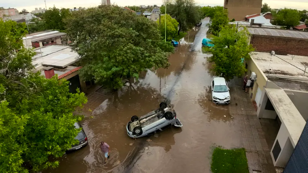 Ein umgestürztes Fahrzeug steht nach einem Unwetter in den Fluten. Foto: Juan Sebastian Lobos/AP/dpa