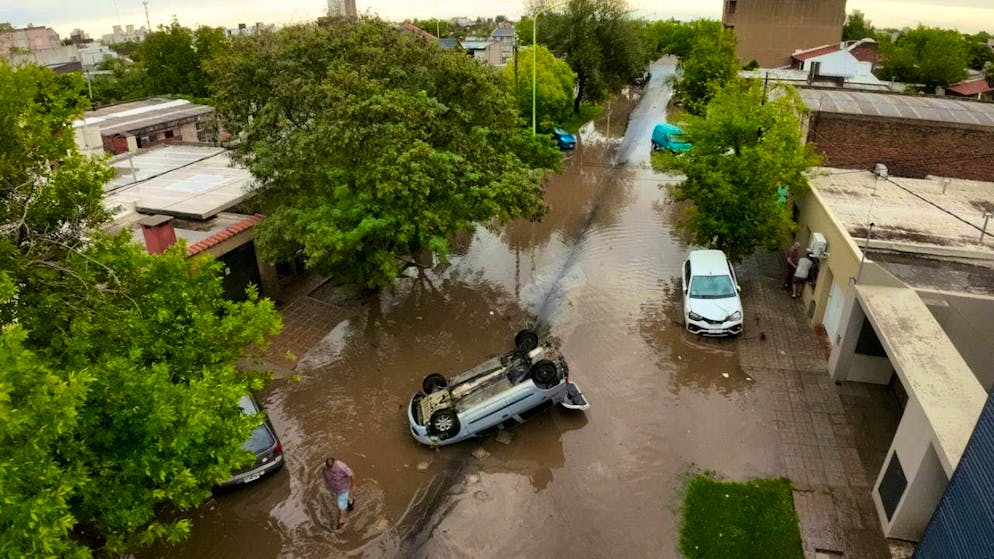 An overturned vehicle stands in the floods after a storm. Photo: Juan Sebastian Lobos/AP/dpa