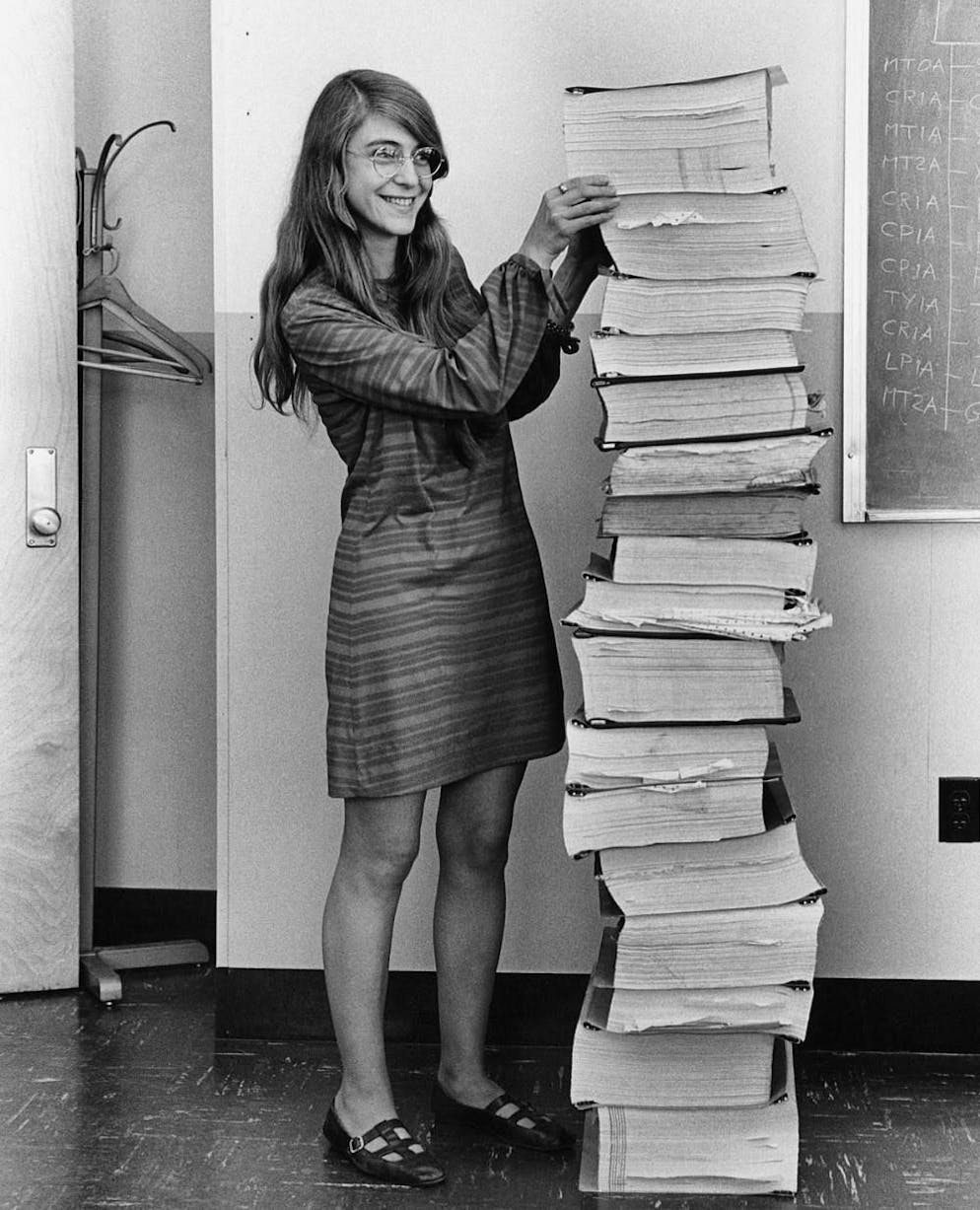 Margaret Hamilton accanto alle stampe del software di volo dell'Apollo.