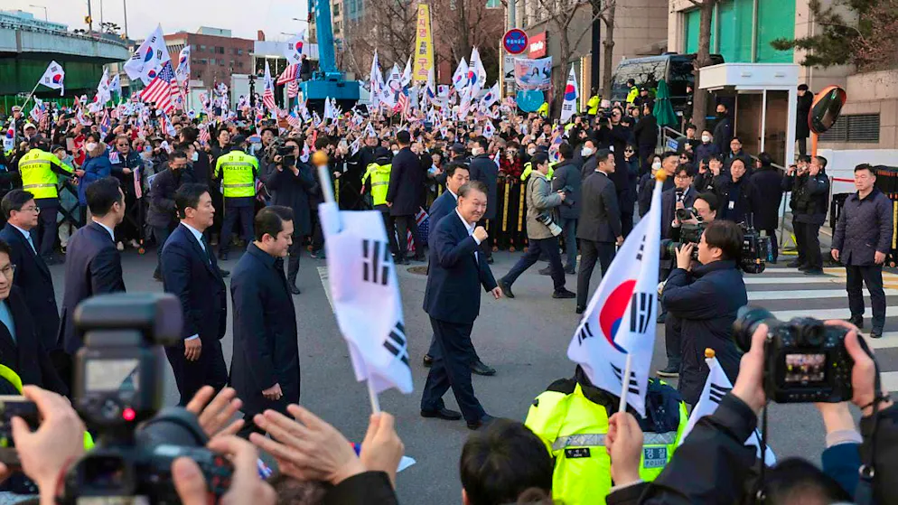 Deposed South Korean President Yoon Suk Yeol greets his supporters as he arrives at the presidential residence. Photo: Yonhap/AP/dpa
