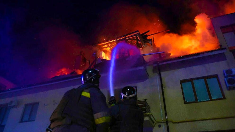 dpatopbilder - Rescue workers extinguish a fire in a burning house that was hit by a Russian drone strike on a residential neighborhood in Zaporizhia (Ukraine). Photo: Kateryna Klochko/AP/dpa