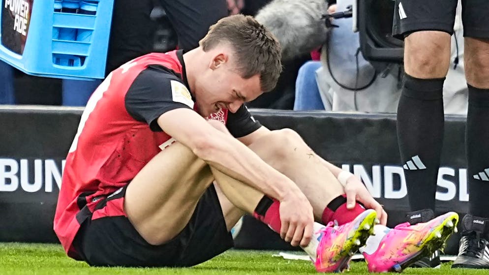 Florian Wirtz krümmt sich nach einem Foul von Mitchell Weiser vor Schmerzen