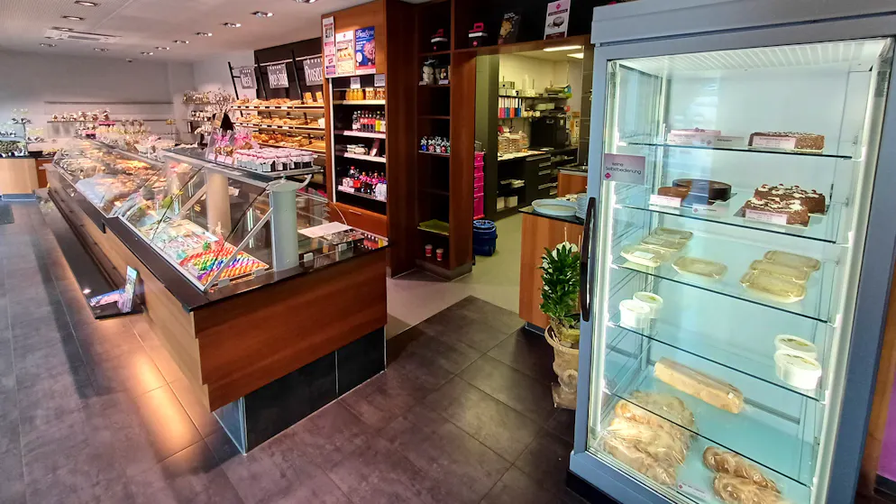 Links die Auslage, rechts der Kühlschrank mit den feinen Torten – und der unscheinbare Gang zu den Arbeitsräumen im hinteren Teil des Hauses. Die Rahm-Truffes-Torte mit 22 Zentimeter Durchmesser kostet hier 38 Franken.