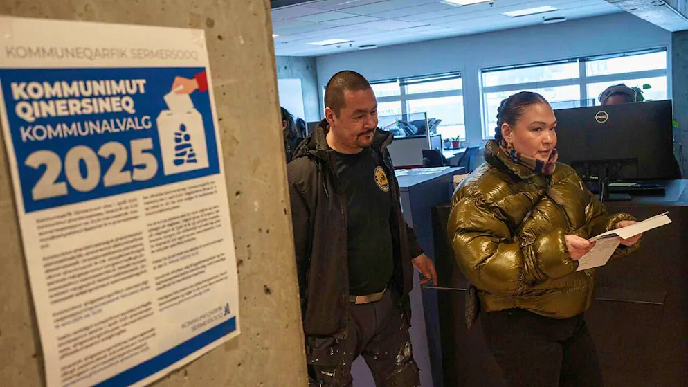 Eine Frau trägt ihren Stimmzettel während einer vorgezogenen Stimmabgabe für die grönländischen Parlamentswahlen im Rathaus in Nuuk. Foto: Evgeniy Maloletka/AP/dpa