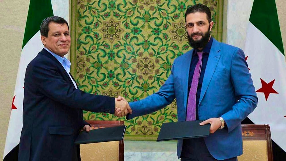 dpatopbilder - HANDOUT - The Syrian president of the transitional government, Ahmed al-Sharaa (r) and Maslum Abdi, the SDF commander-in-chief, shake hands. Photo: -/SANA/dpa - ATTENTION: For editorial use only and only with full citation of the above credit